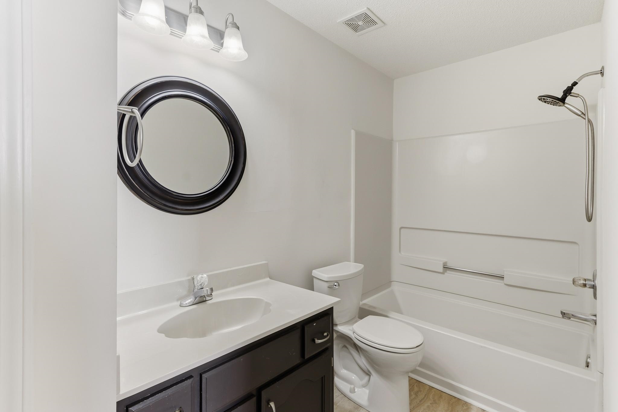 1066 Whitten Road Cordova, TN 38018 - Photo 17 of 30 a bathroom with a granite countertop toilet a sink and a mirror