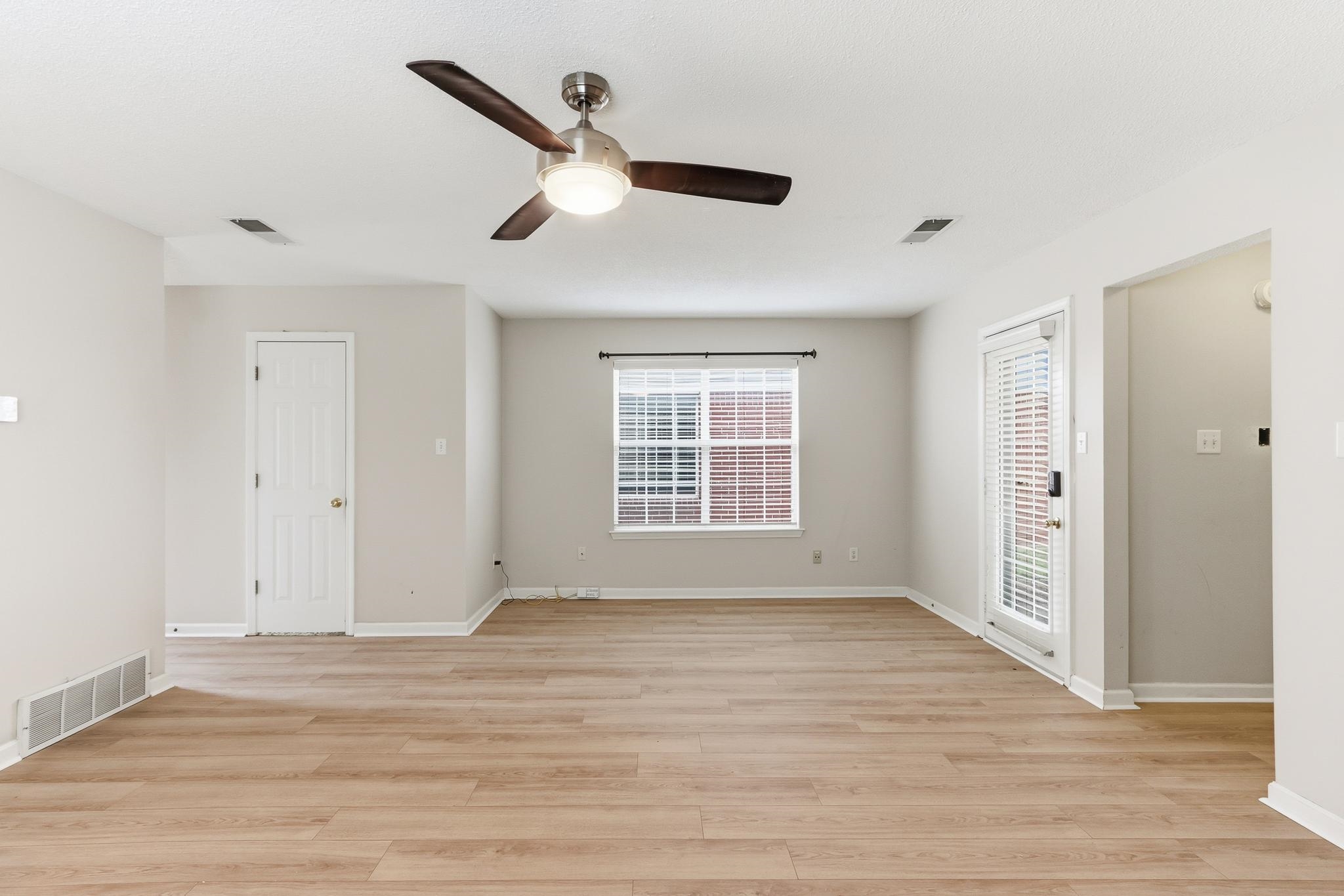 1066 Whitten Road Cordova, TN 38018 - Photo 9 of 30 a view of an empty room with wooden floor and a window