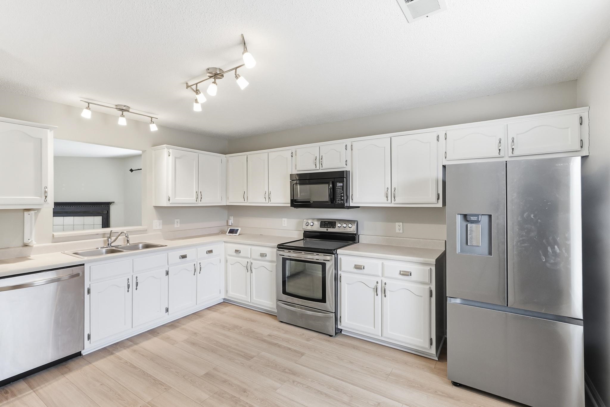 1066 Whitten Road Cordova, TN 38018 - Photo 10 of 30 a kitchen with granite countertop white cabinets and stainless steel appliances