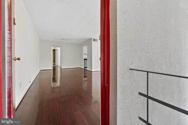 a view of a hallway with wooden floor