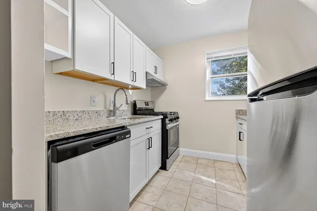 a kitchen with stainless steel appliances a sink stove and a refrigerator
