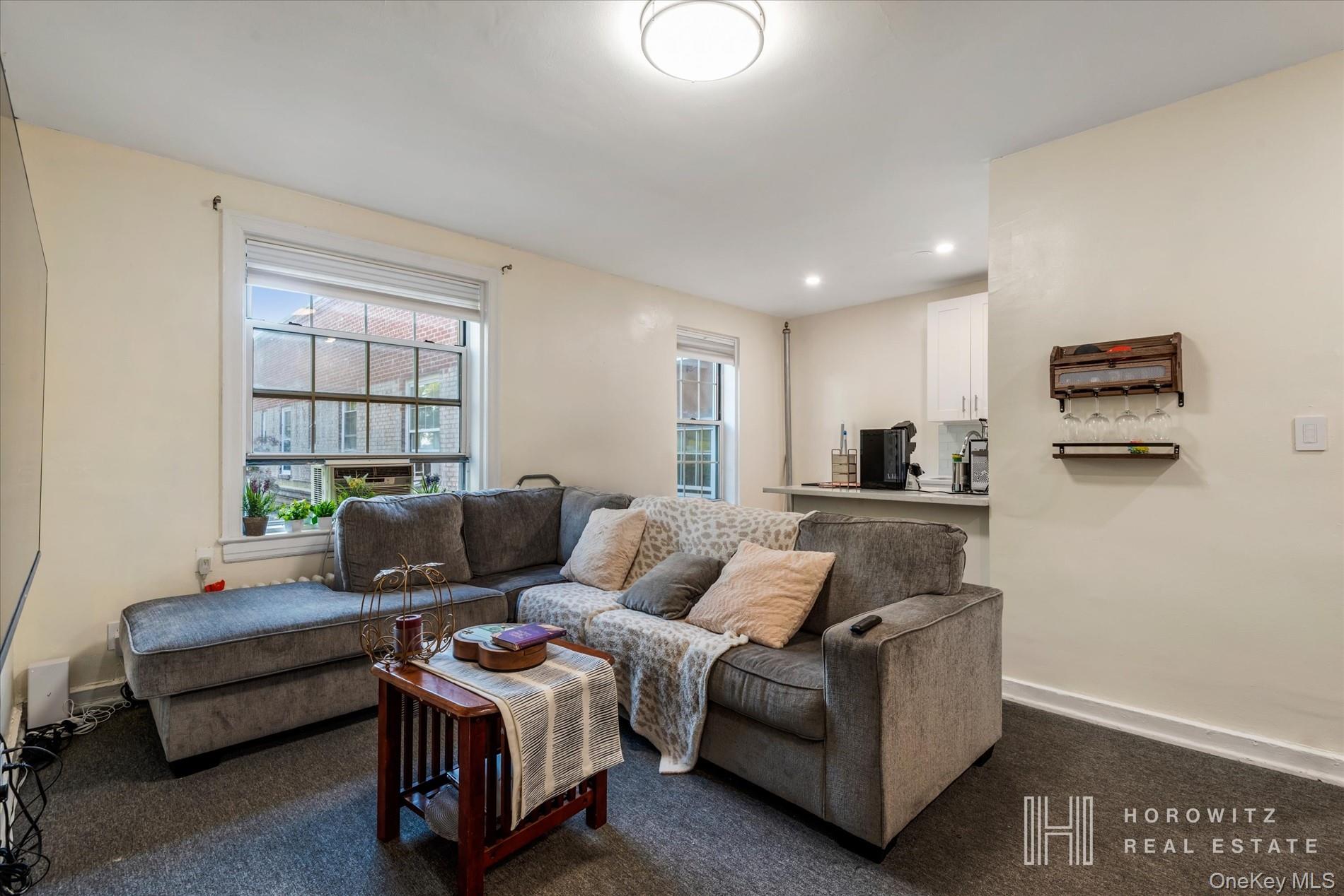 55-03 31st Avenue, Unit C6K Queens, NY 11377 - Photo 1 of 13 a living room with furniture and a window