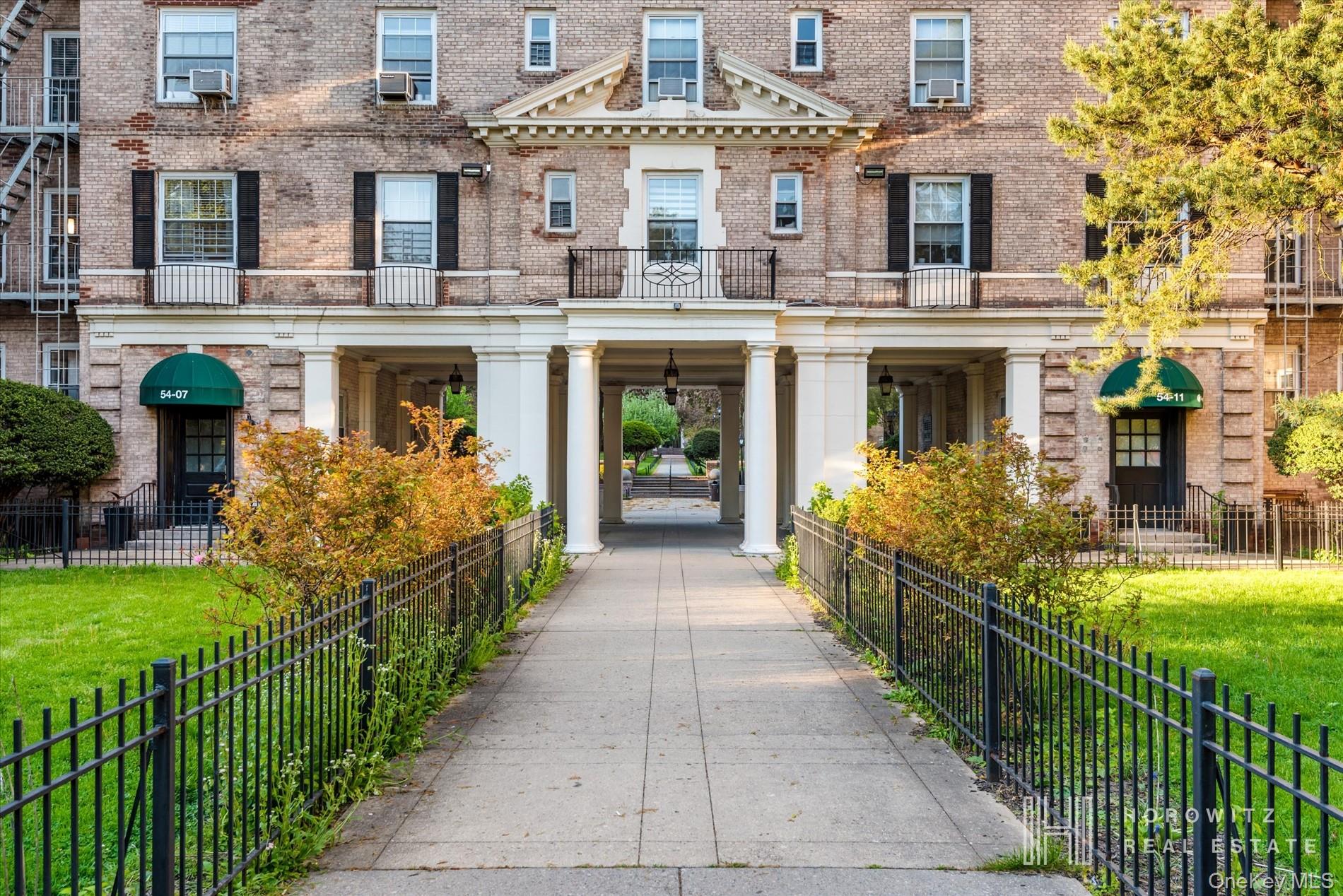 55-03 31st Avenue, Unit C6K Queens, NY 11377 - Photo 12 of 13 a view of a house with many windows plants and large trees