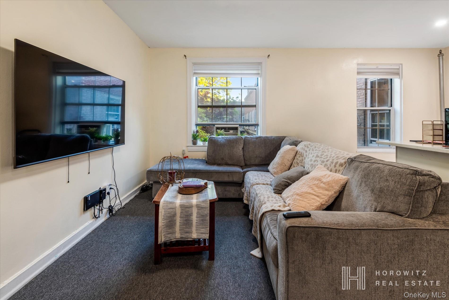 55-03 31st Avenue, Unit C6K Queens, NY 11377 - Photo 2 of 13 a living room with furniture and a flat screen tv