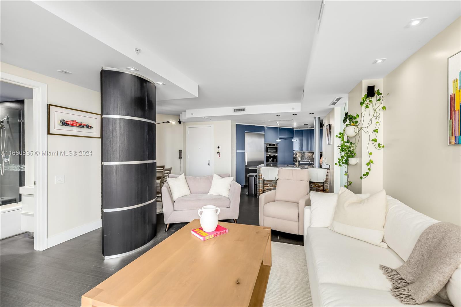 888 Brickell Key Drive, Unit 710 Miami, FL 33131 - Photo 17 of 45 a living room with furniture a refrigerator and a wooden floor