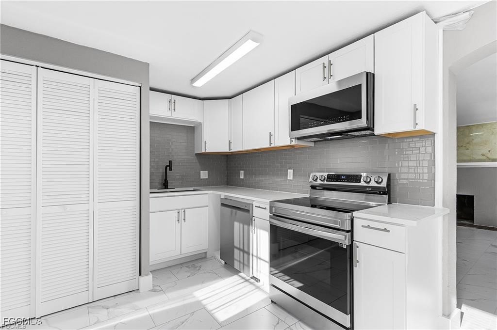 4472 East Riverside Drive Fort Myers, FL 33905 - Photo 15 of 17 a kitchen with stainless steel appliances a stove microwave and sink