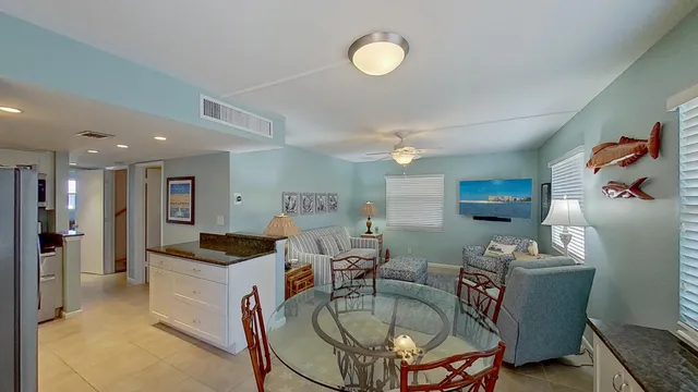 a kitchen island with stainless steel appliances granite countertop a sink and a refrigerator