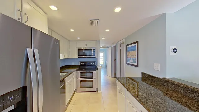 a kitchen with stainless steel appliances granite countertop a refrigerator sink and stove