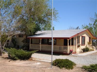 10871 Wilson Ranch Road, Unit 197 Phelan, CA 92371 - Photo 1 of 1 a view of a house with a yard and potted plants
