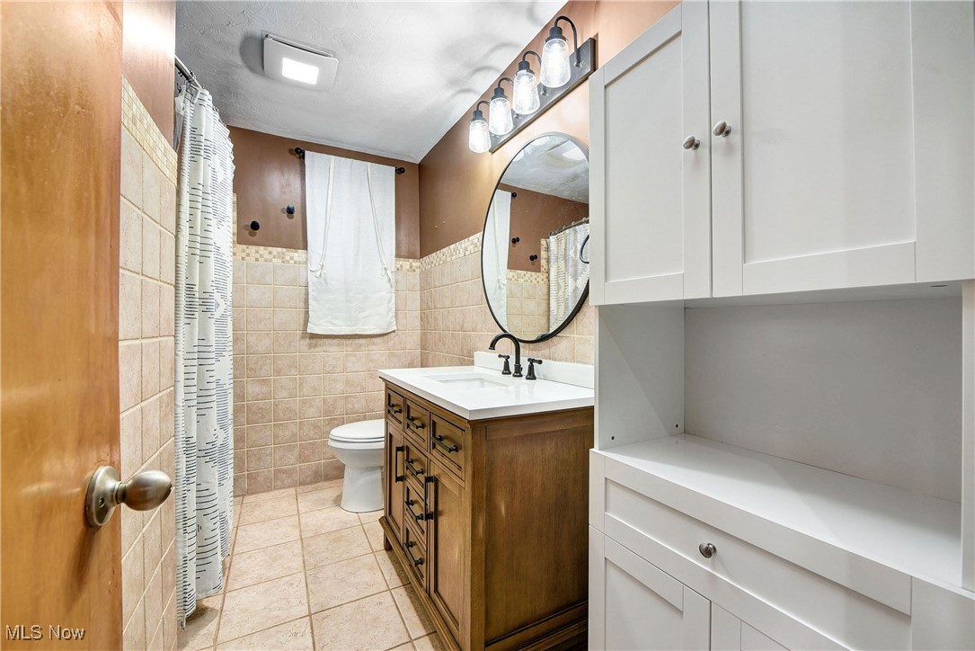 11518 Prospect Road Strongsville, OH 44149 - Photo 21 of 46 Full bathroom featuring tile walls, toilet, tile patterned floors, and vanity
