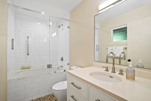 a bathroom with a sink a toilet and shower