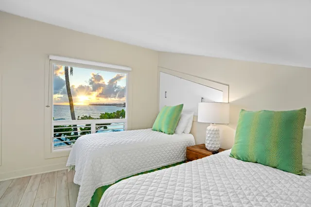 a bedroom with two beds and a large window