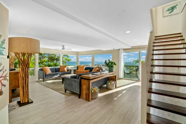 a living room with furniture a lamp wooden floor and a large window