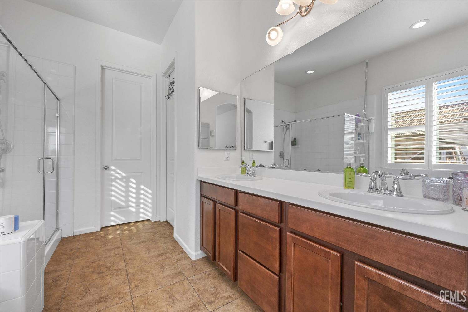 Undisclosed Address Bakersfield, CA 93314 - Photo 30 of 56 a spacious bathroom with a double vanity sink a mirror and a shower