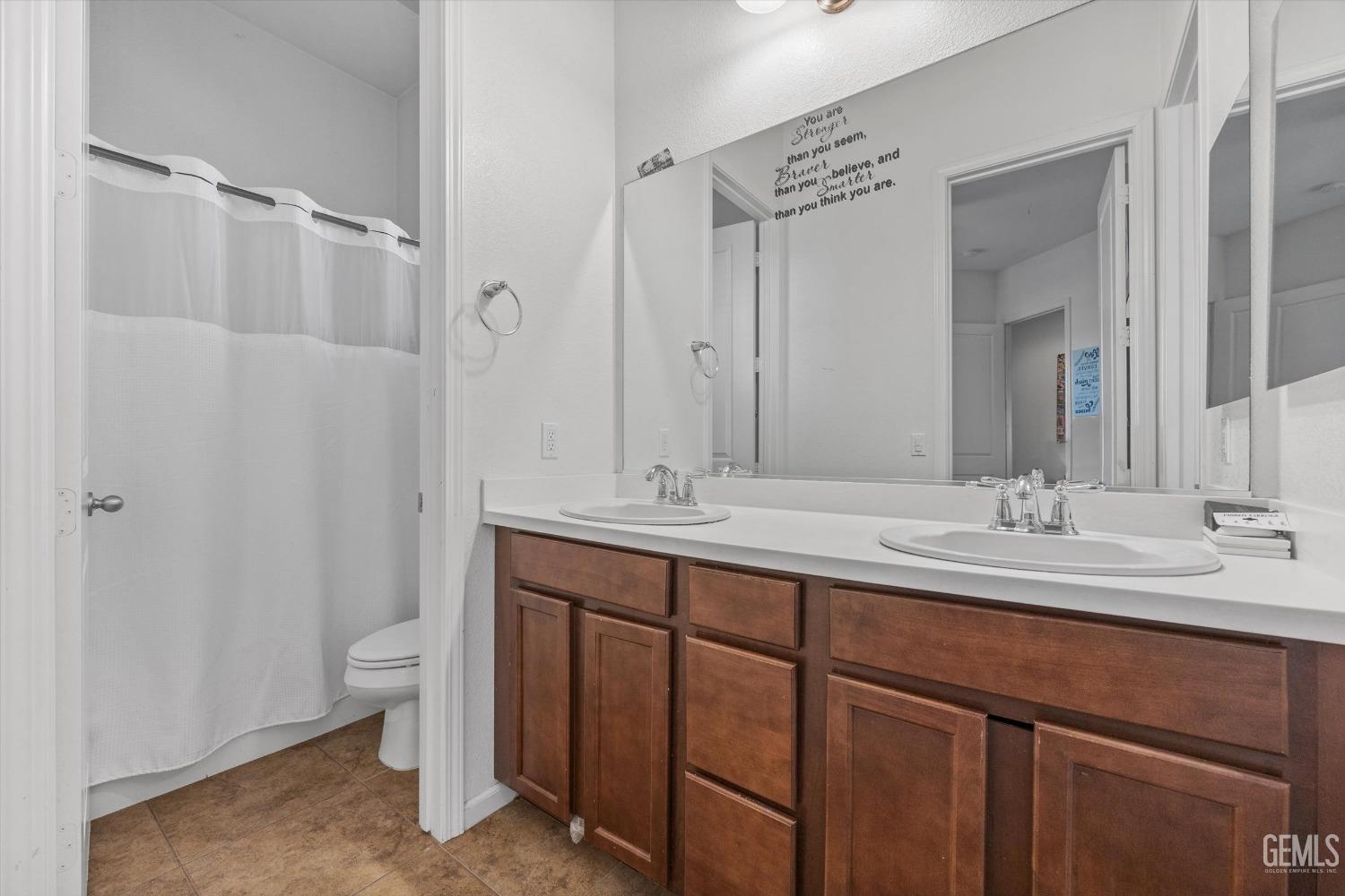 Undisclosed Address Bakersfield, CA 93314 - Photo 34 of 56 a bathroom with a double vanity sink and a mirror