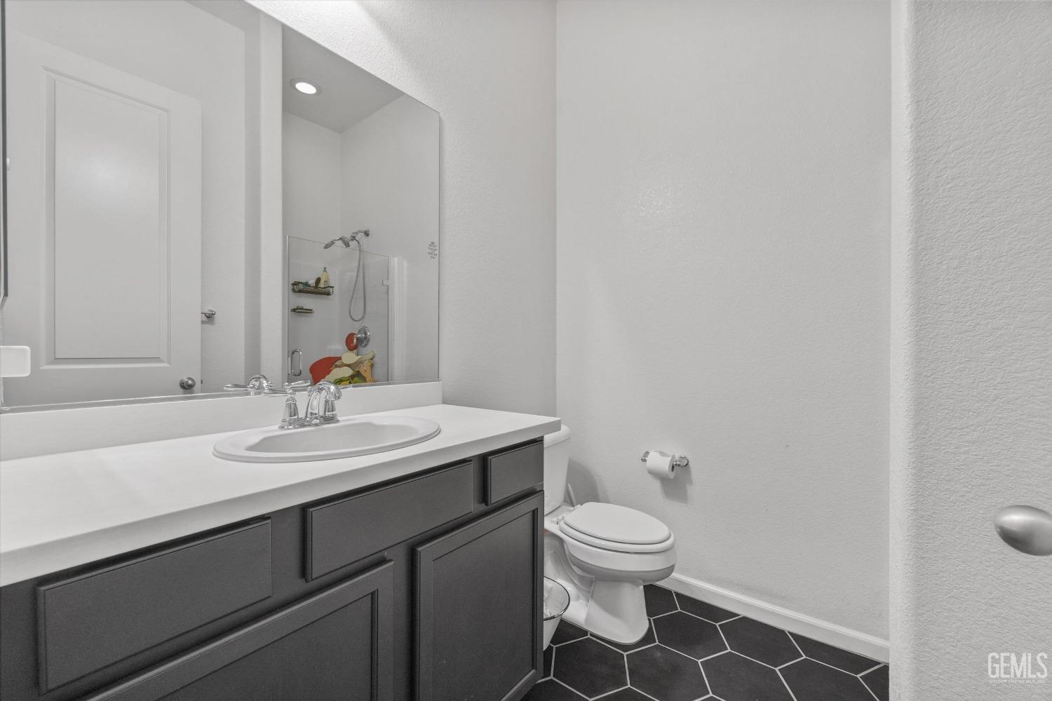 Undisclosed Address Bakersfield, CA 93314 - Photo 40 of 56 a bathroom with a granite countertop sink a toilet and a mirror