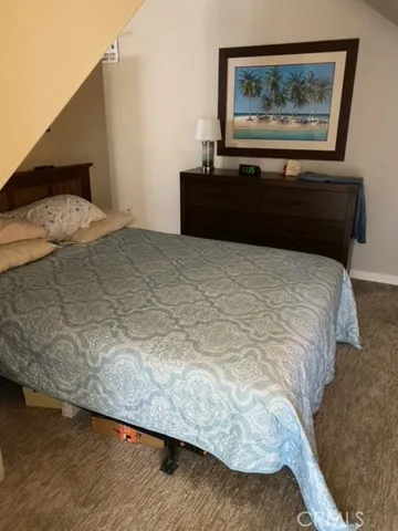 a bedroom with a bed and a painting on the wall
