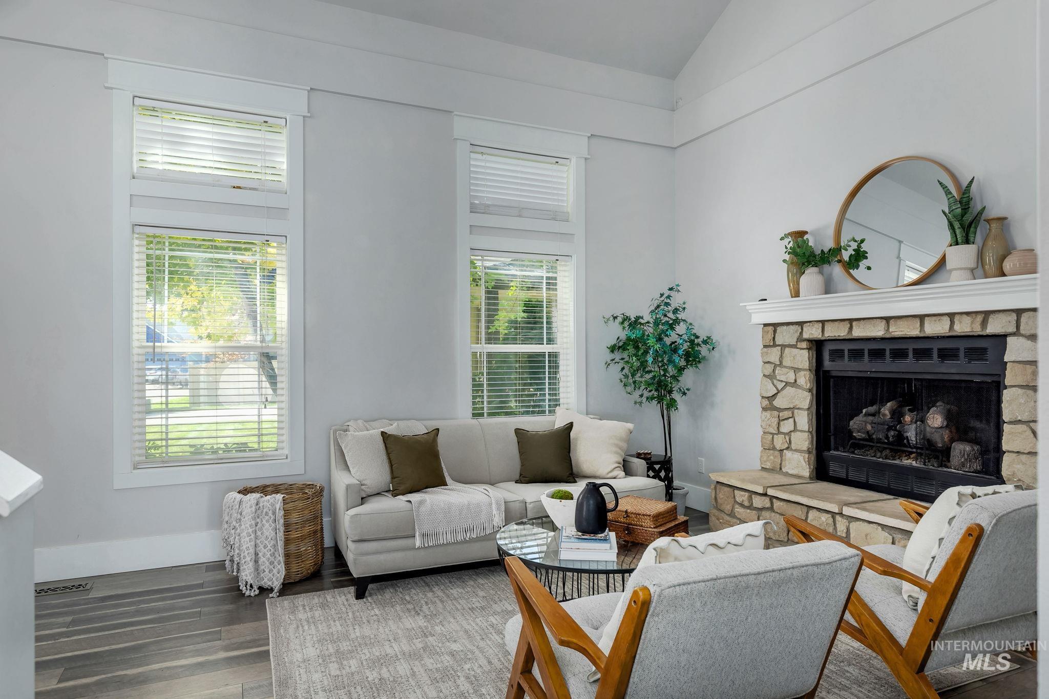 2912 East Bonfire Lane Eagle, ID 83616 - Photo 19 of 50 Living area with a stone fireplace, wood finished floors, and high vaulted ceiling