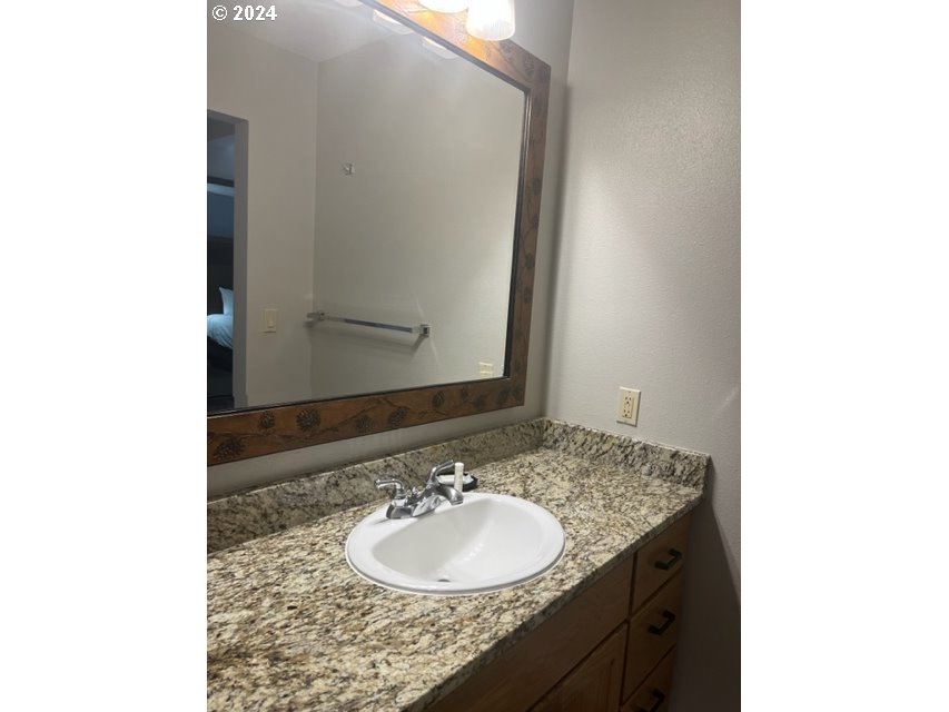 18575 Southwest Century Drive, Unit 1721&22 Bend, OR 97702 - Photo 35 of 40 a bathroom with a granite countertop sink and a mirror