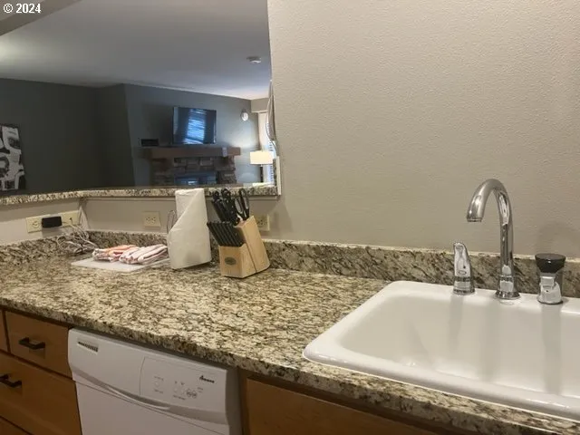 a bathroom with a granite countertop sink and a white cabinets