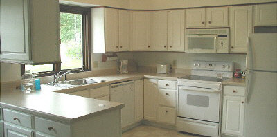 11873 Tresemer Road Roscoe, IL 61073 - Photo 2 of 6 a kitchen with white cabinets and white appliances