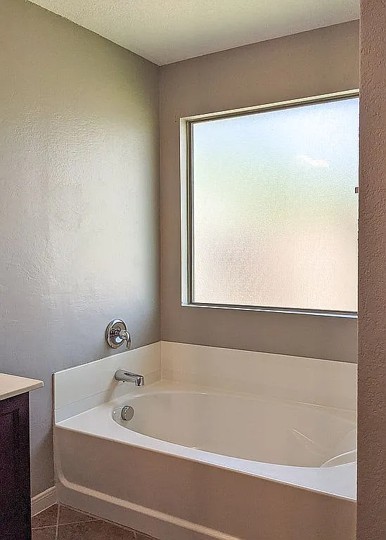 7703 Redstone Manor Converse, TX 78109 - Photo 12 of 28 Bathroom featuring a bath, vanity, a textured wall, and a textured ceiling