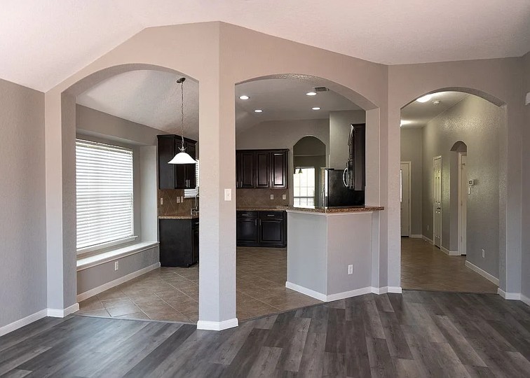 7703 Redstone Manor Converse, TX 78109 - Photo 3 of 28 Kitchen featuring tasteful backsplash, arched walkways, dark wood-type flooring, light stone countertops, and hanging light fixtures