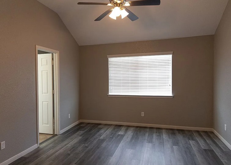 7703 Redstone Manor Converse, TX 78109 - Photo 8 of 28 Unfurnished room featuring ceiling fan, dark wood-type flooring, and vaulted ceiling