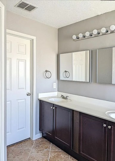 7703 Redstone Manor Converse, TX 78109 - Photo 10 of 28 Full bathroom featuring a textured ceiling and double vanity