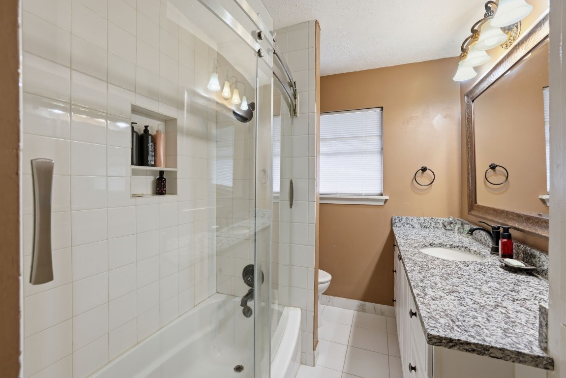 10922 Ivyridge Road Houston, TX 77043 - Photo 11 of 17 a bathroom with a granite countertop sink a mirror and shower