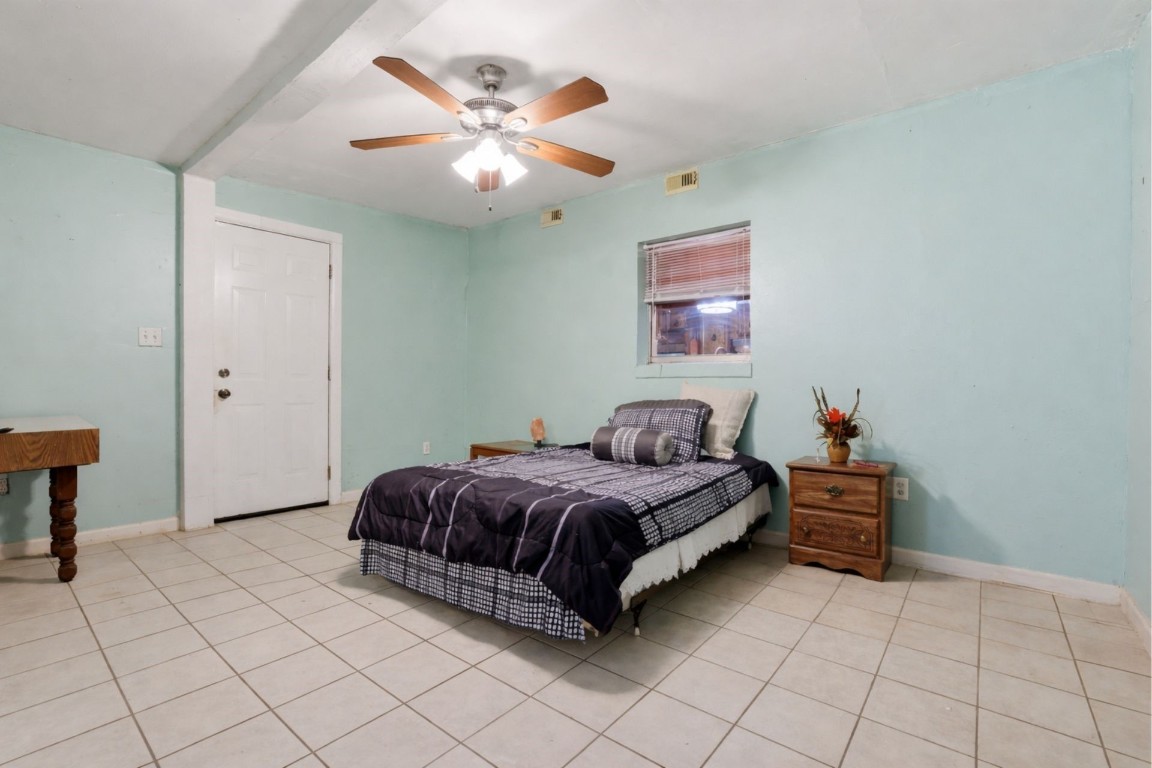 10922 Ivyridge Road Houston, TX 77043 - Photo 14 of 17 a bedroom with a bed and a chandelier