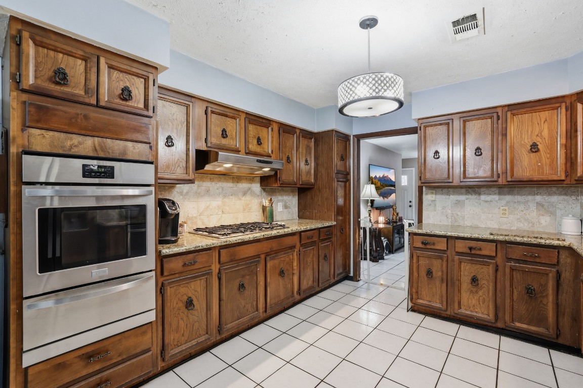 10922 Ivyridge Road Houston, TX 77043 - Photo 6 of 17 a kitchen with stainless steel appliances granite countertop a stove and cabinets