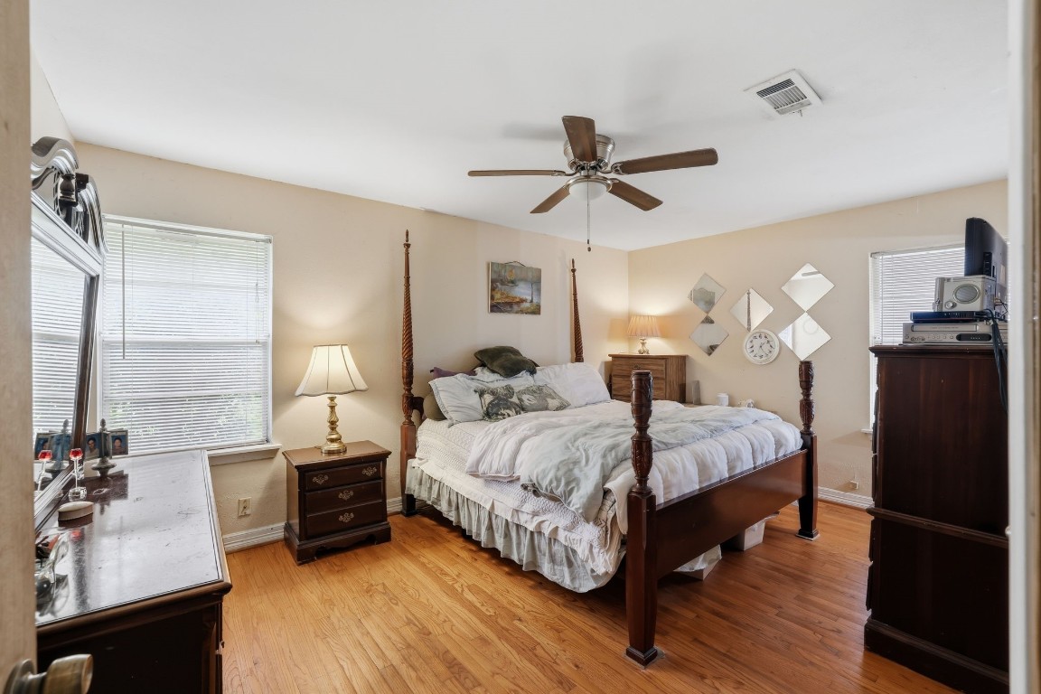 10922 Ivyridge Road Houston, TX 77043 - Photo 8 of 17 a spacious bedroom with a bed and wooden floor