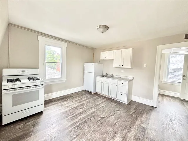 a kitchen with white cabinets and white appliances