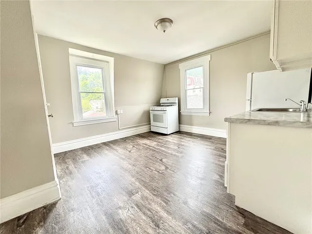 a big room with wooden floor and windows