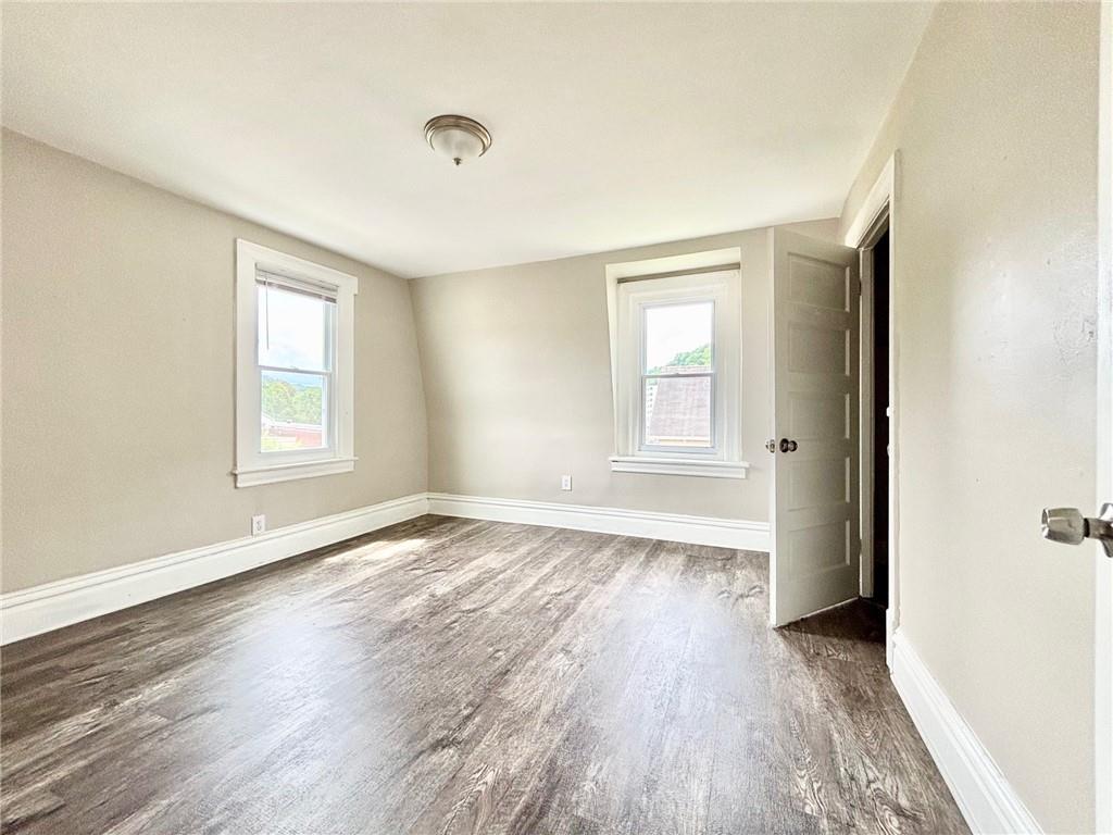 352 2nd Street, Unit 3 Pitcairn, PA 15140 - Photo 5 of 8 an empty room with wooden floor and windows
