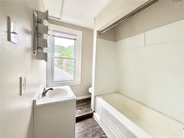 a bathroom with a tub a sink and mirror