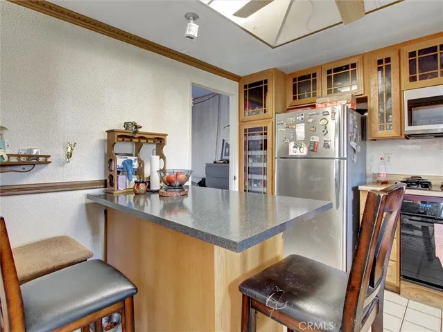 a kitchen with stainless steel appliances granite countertop a sink refrigerator and cabinets