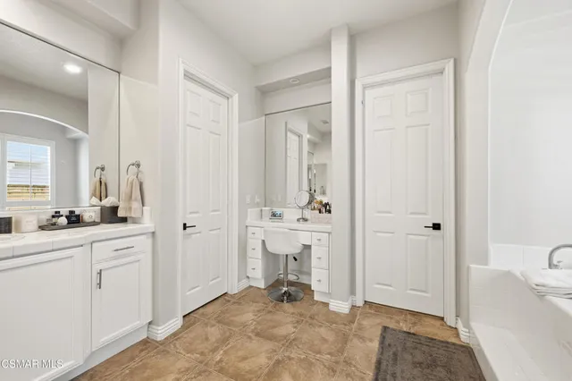 a view of a bathroom with sink mirror and window