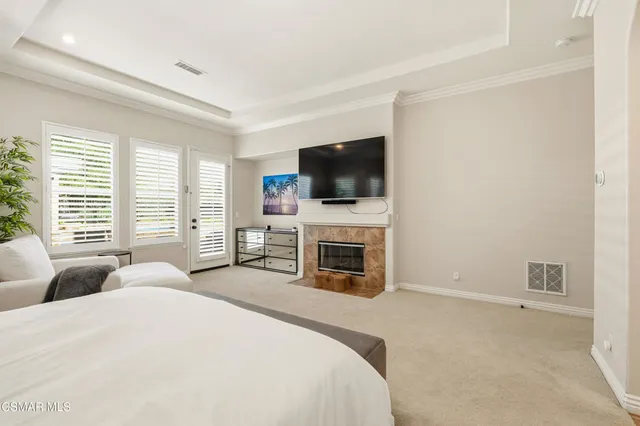 a spacious bedroom with a bed and a flat screen tv