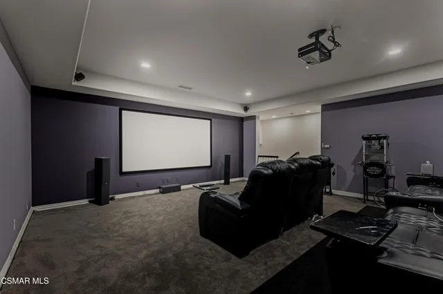 a room with furniture projector and screen