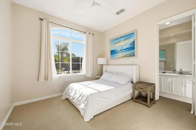 a bedroom with a bed a table and painting