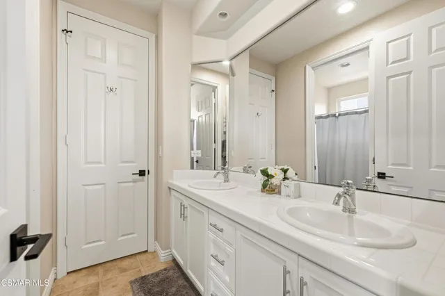 a bathroom with a double vanity sink and a mirror