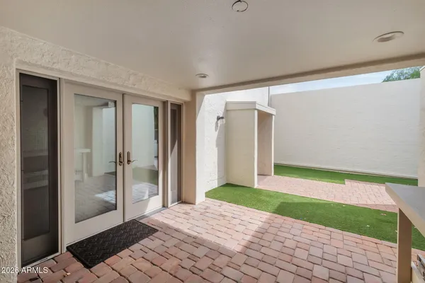 an empty room with chandelier fan and windows