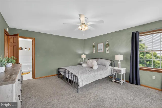 a spacious bathroom with a toilet a sink and a mirror