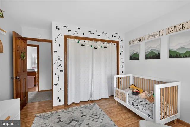 a view of staircase with lots of frames on wall and wooden floor