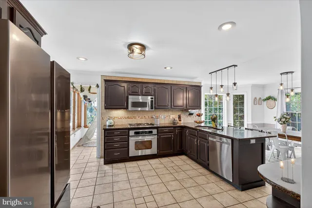 a large kitchen with stainless steel appliances granite countertop a stove and a sink