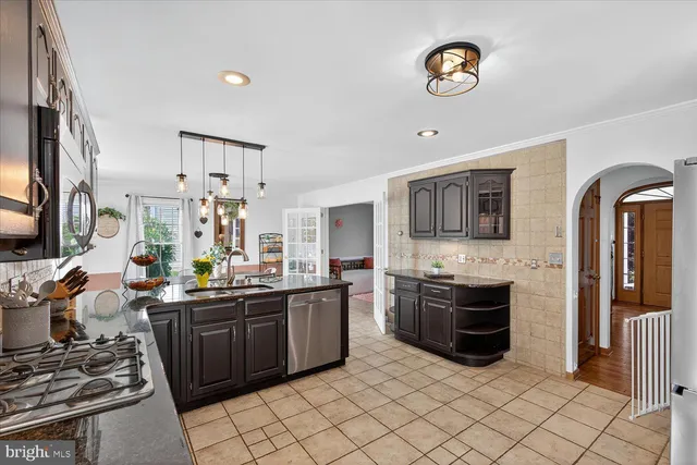 a kitchen with stainless steel appliances granite countertop a refrigerator a stove top oven a sink and dishwasher