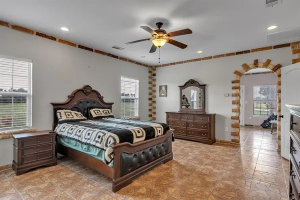 a bedroom with a bed chandelier and a window