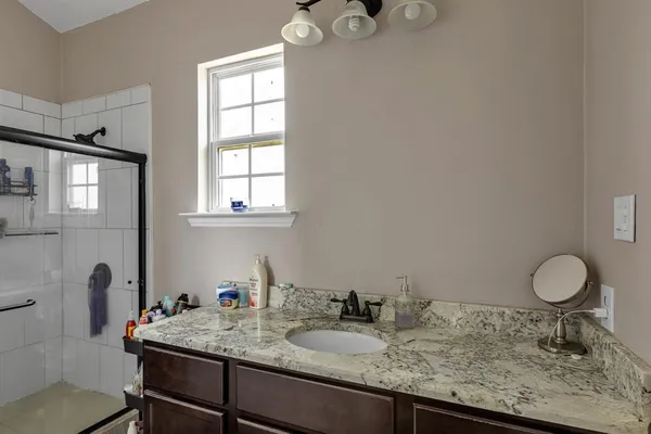 a bathroom with a granite countertop sink and a mirror